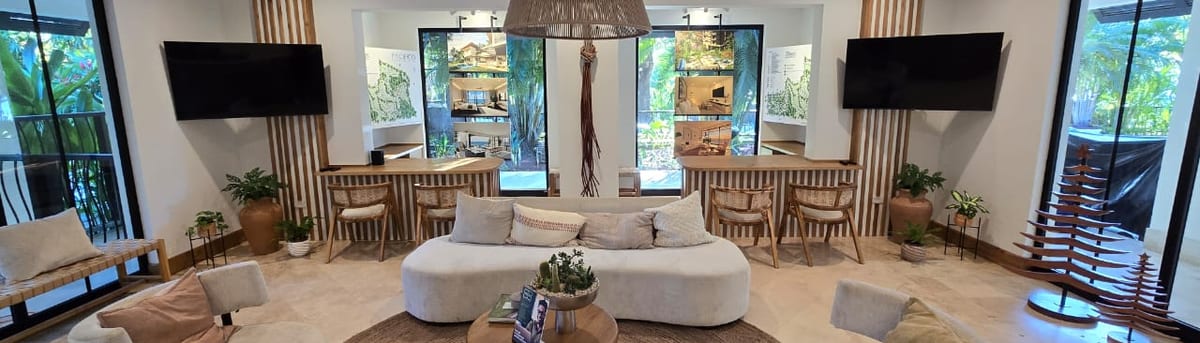 Pacifico Beach Club lounge with curved sofas, a woven pendant lamp and a jute rug